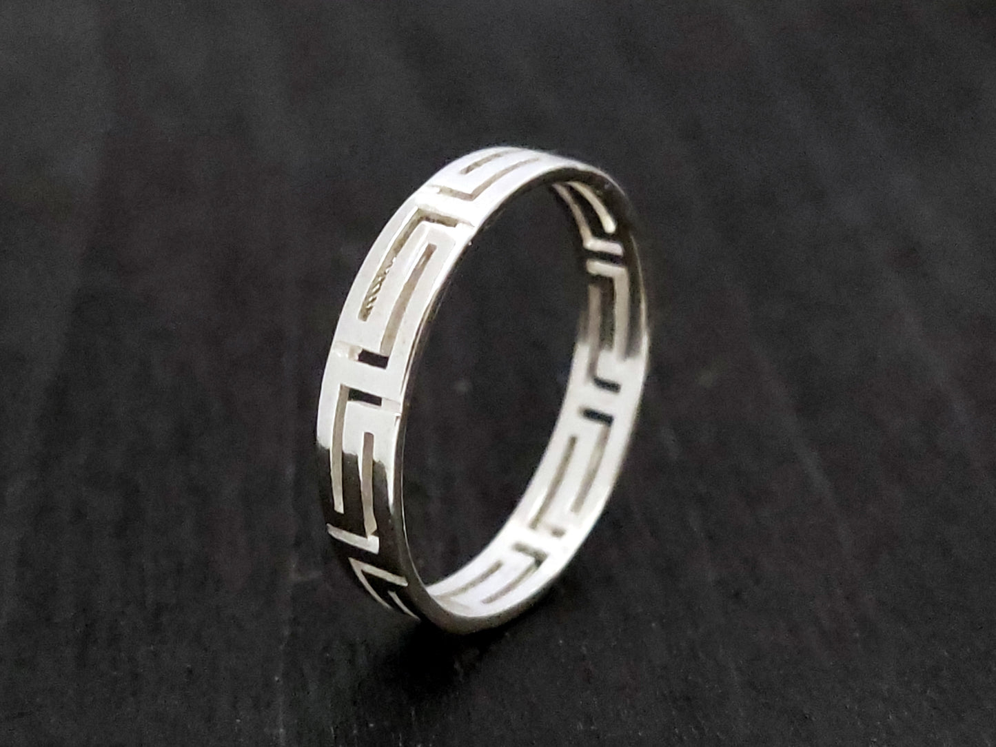 Silver ring with the Greek Key measuring 4mm on black background.