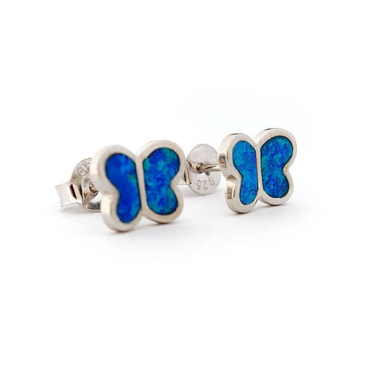 Butterfly-shaped silver earrings with blue opal inlay on a white background