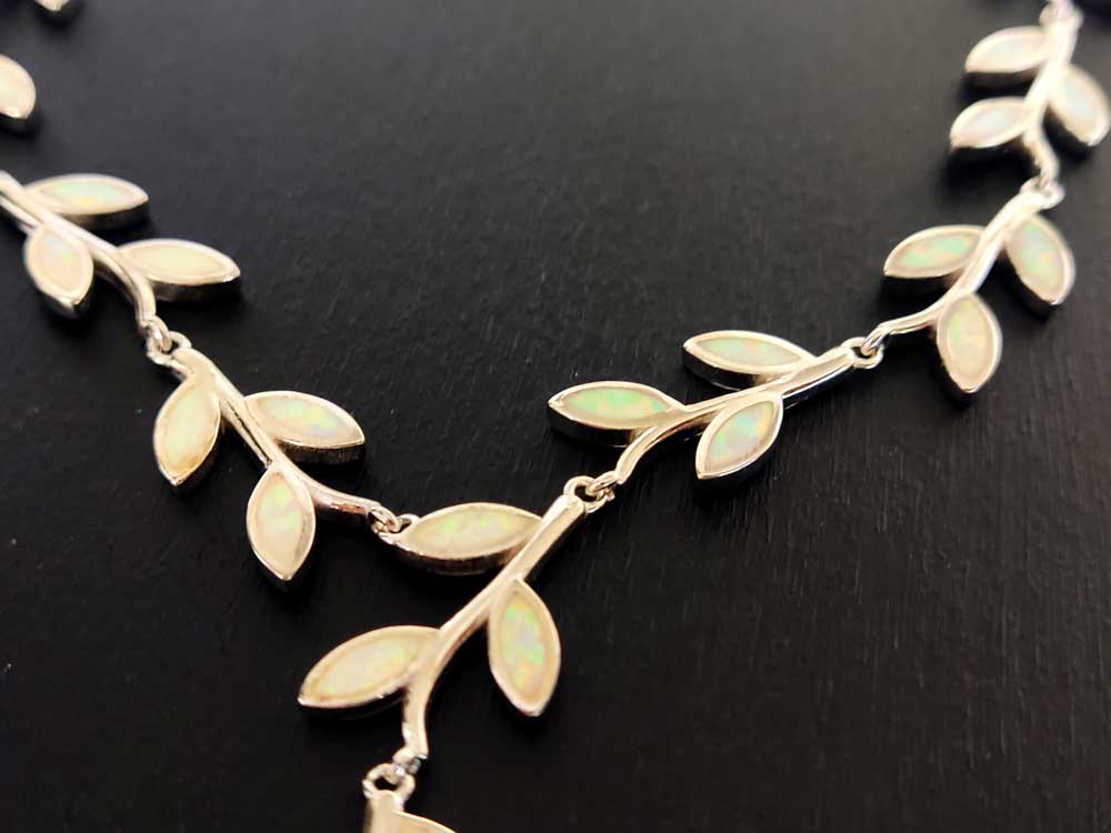 Close up photo of Greek silver necklace with leaves shape white opal stones.
