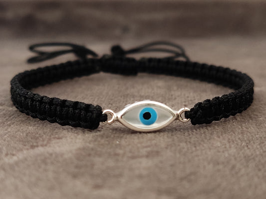 Evil eye silver macrame bracelet on gray velvet.