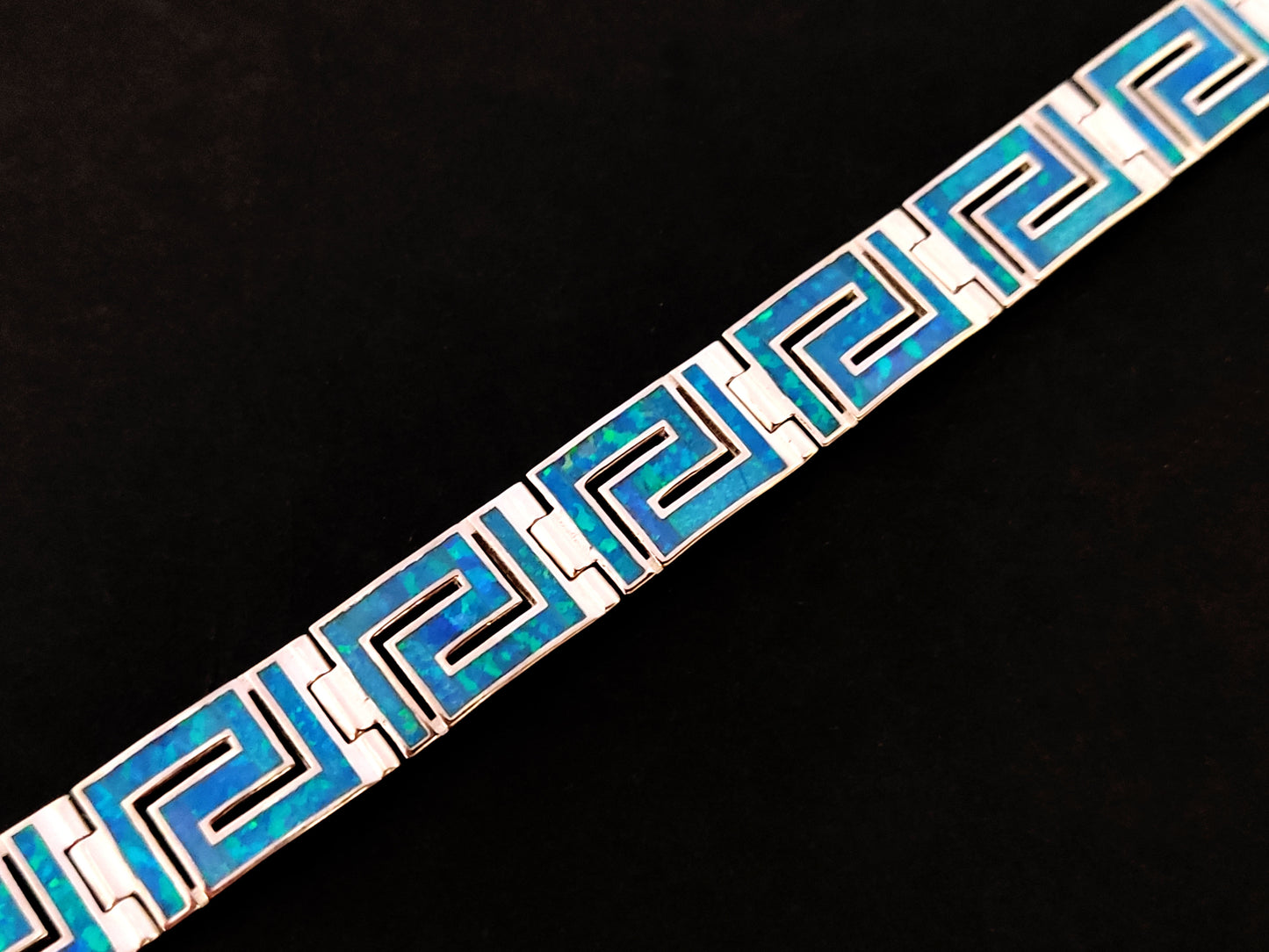 Close-up image of a Greek Sterling Silver 925 Fire Rainbow Blue Opal Bracelet with Ancient Eternity Key Meander Design, showcasing the intricate details and brilliant blue opal centerpiece.