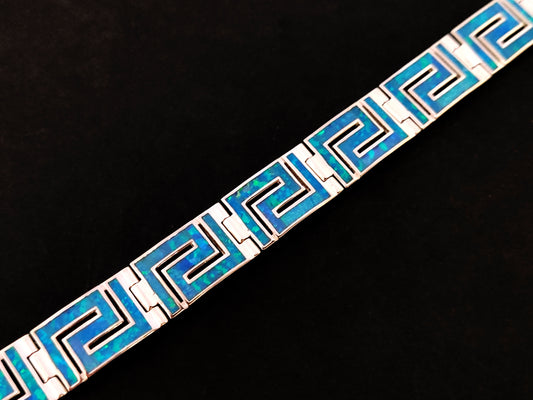 Close-up image of a Greek Sterling Silver 925 Fire Rainbow Blue Opal Bracelet with Ancient Eternity Key Meander Design, showcasing the intricate details and brilliant blue opal centerpiece.