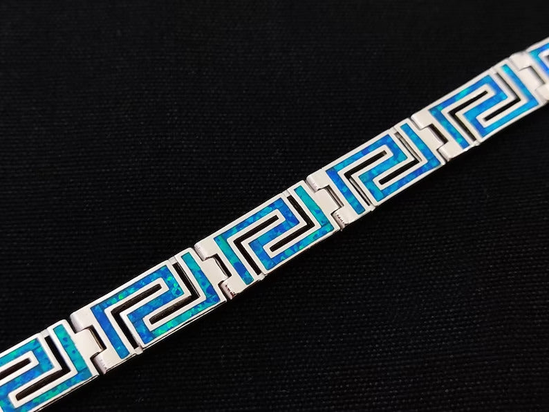 Greek Key silver bracelet with blue opal stones on black background