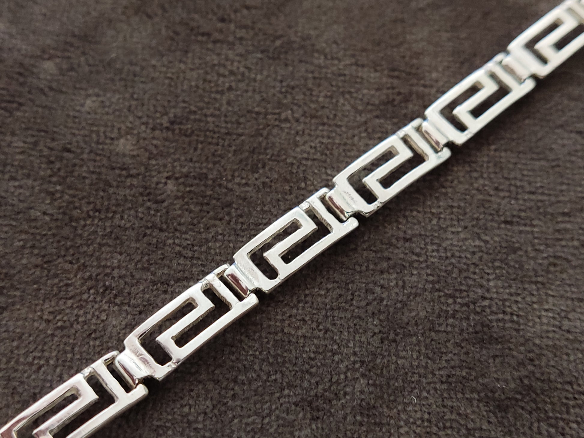 Greek key bracelet made of sterling silver 925 measuring 6mm width on gray velvet background.
