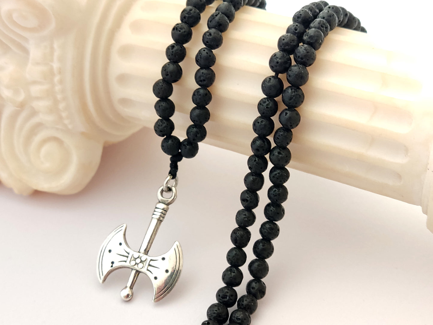 Greek silver double axe pendant called labris set on a necklace made of natural volcanic lava stones measuring 4mm.