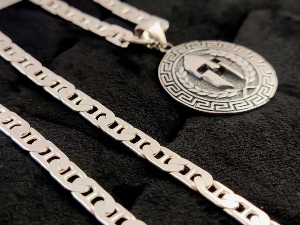 Spartan Warrior Pendant with Greek Key Design – Pendant displayed on a textured background, emphasizing its ancient Greek warrior aesthetic.