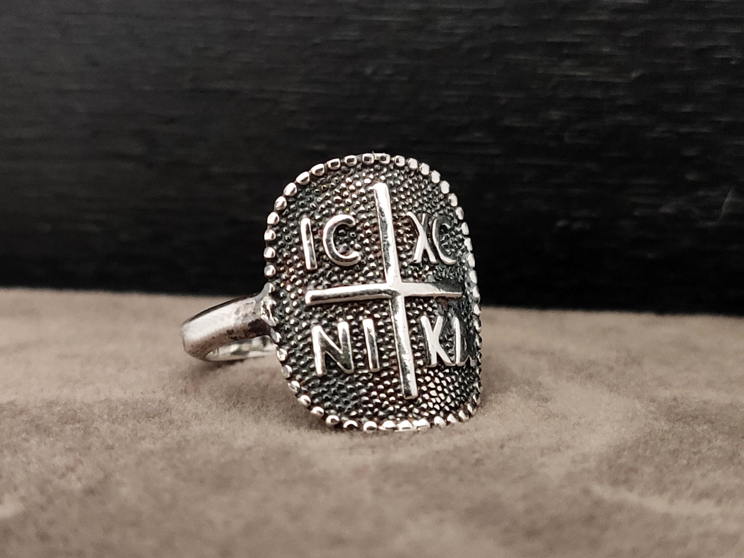 Silver ring with the konstantinato byzantine design. it has a cross in the middle and the letters ICXC NIKA .