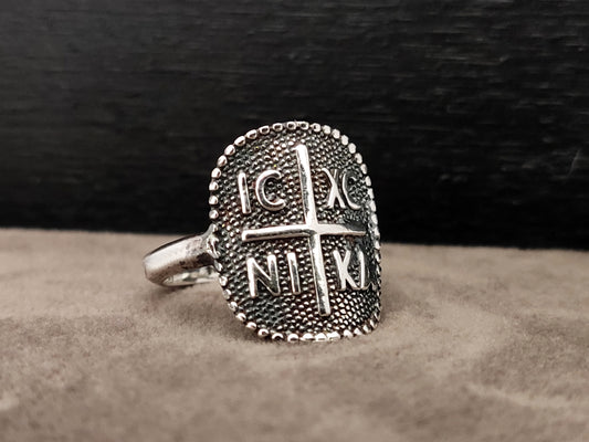 Silver ring with the konstantinato byzantine design. it has a cross in the middle and the letters  ICXC NIKA .