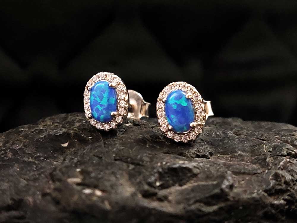 Blue opal earrings on a jewelry display – Elegant, hypoallergenic, and perfect for everyday wear or special occasions.