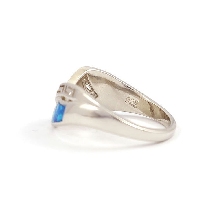 Sideview of a Greek silver ring with a blue opal on a white background