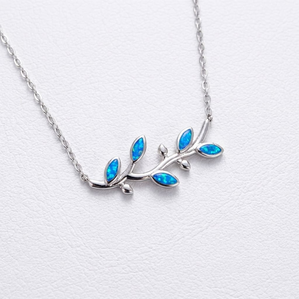 Silver Greek necklace with blue opal leaves on a white leather background
