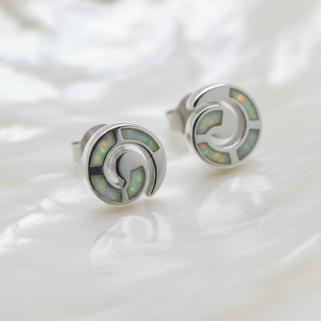 Close-up of white opal stones in silver infinity spiral studs