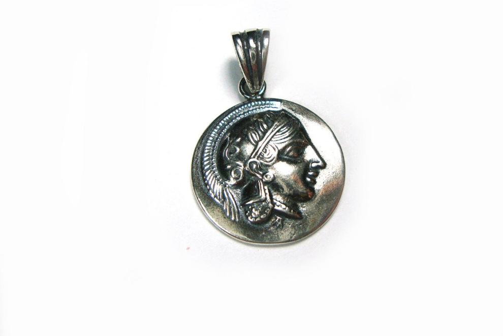 Close-up image of a Sterling Silver 925 Pendant featuring a Gold-Plated Ancient Greek Goddess Athena emblem, symbolizing wisdom and strength, against a backdrop of olive groves and marble pillars.
