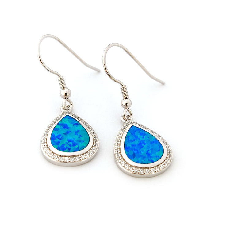 Teardrop-shaped blue opal earrings with silver hooks on a white background