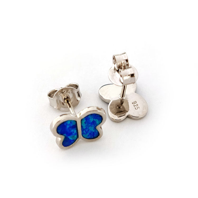 Back side of butterfly-shaped silver earrings with blue center on a white background