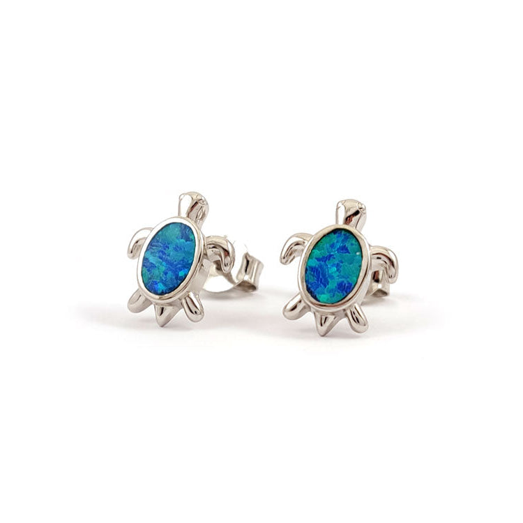 Turtle-shaped earrings with blue opal stones on a white background