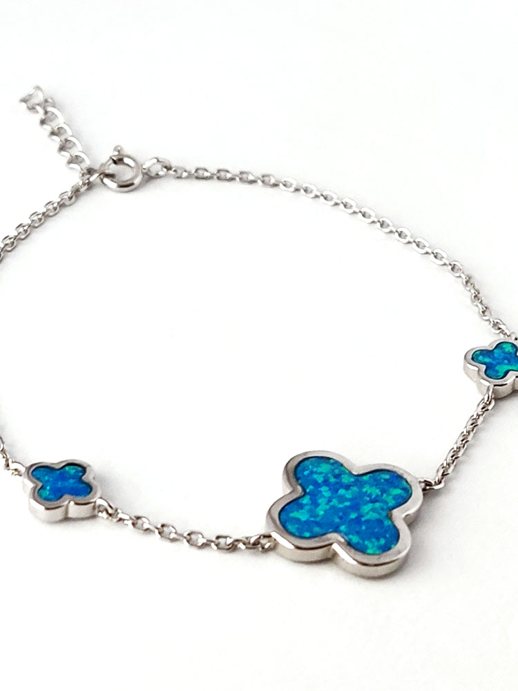 Close-up of a hallmarked 925 silver bracelet showcasing vibrant blue opal inlays arranged in a triple-cross design.