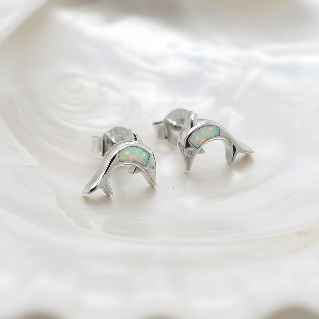 Sterling silver 925 white opal dolphin stud earrings on white background
