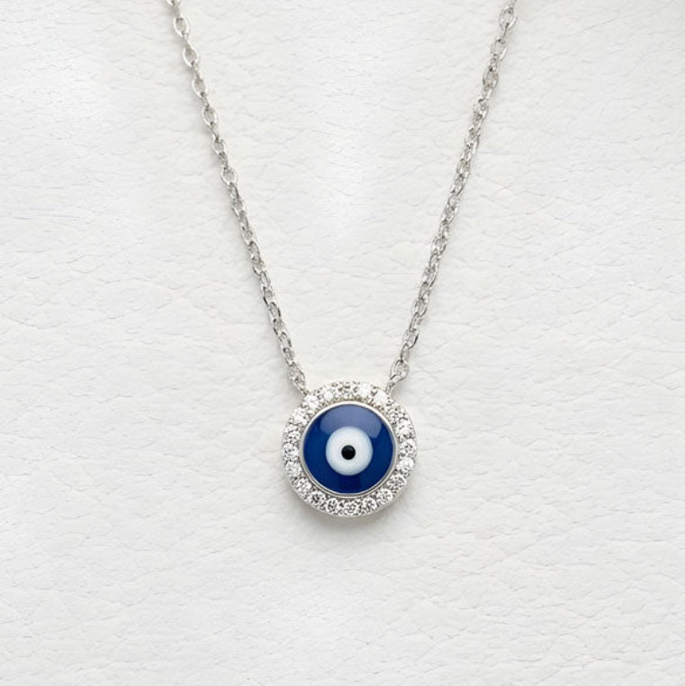Necklace with a blue evil eye pendant on a white surface
