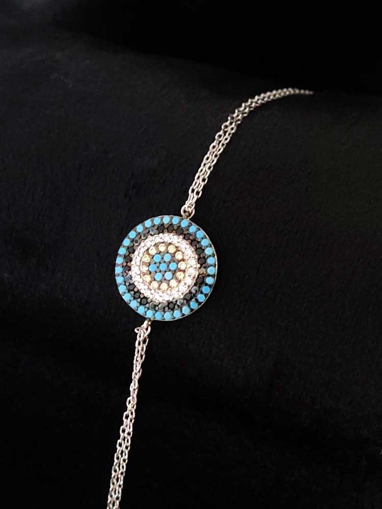 Close-up of a sterling silver Greek Evil Eye pendant featuring turquoise and crystal accents, diameter 1.4 cm, on an adjustable 16–19 cm chain, symbolizing protection and luck.