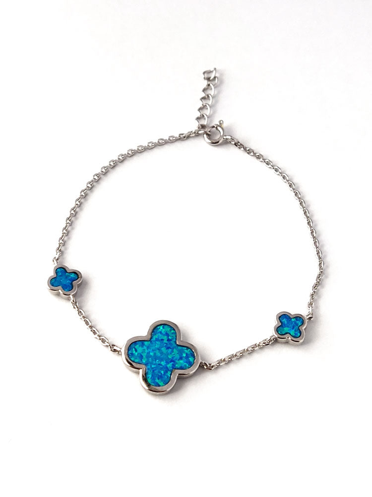 Detail view of the 925 hallmark on a sterling silver bracelet accented with three blue opal crosses.