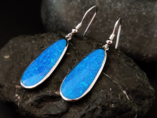 Blue Opal Drop Shape Silver Dangle Earrings - 24x10mm oval earrings featuring captivating blue opal and elegant silver design.
