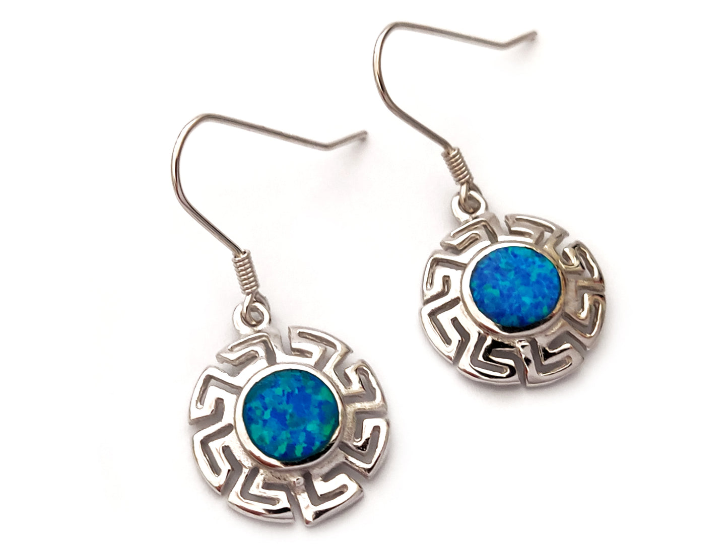Greek silver earrings in round shape with the Greek Key and blue opal stones on white background.
