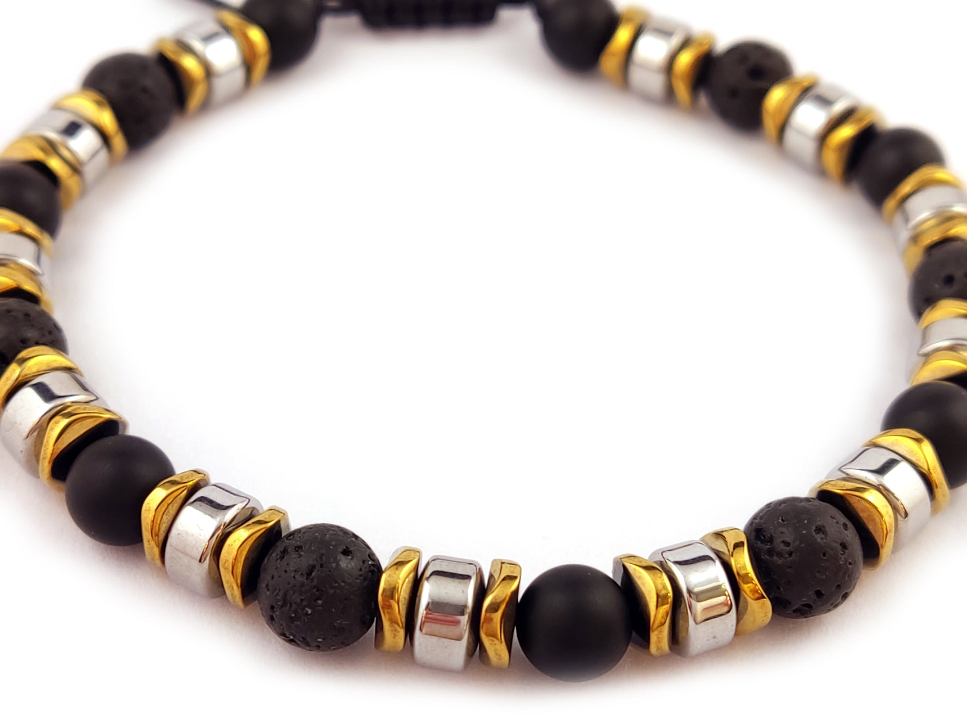 Close-up of the Lava & Hematite Adjustable Bracelet showcasing natural volcanic lava beads, silver and gold-colored hematite accents, and an adjustable cord for a perfect fit.

