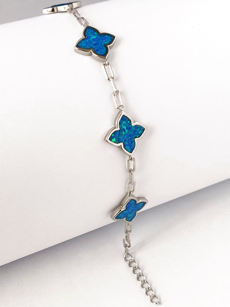 Adjustable silver bracelet with blue opal stones in the shape of a cross. made in Greece and hallmarked 925.