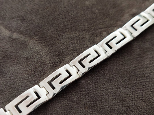 Greek key bracelet for men and women made of sterling silver 925 measuring 9mm width on gray velvet background.