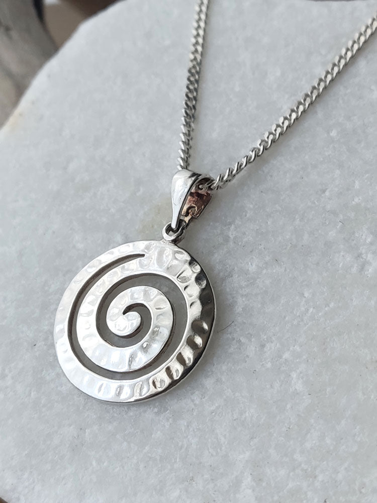 Close up hammered spiral sterling silver pendant