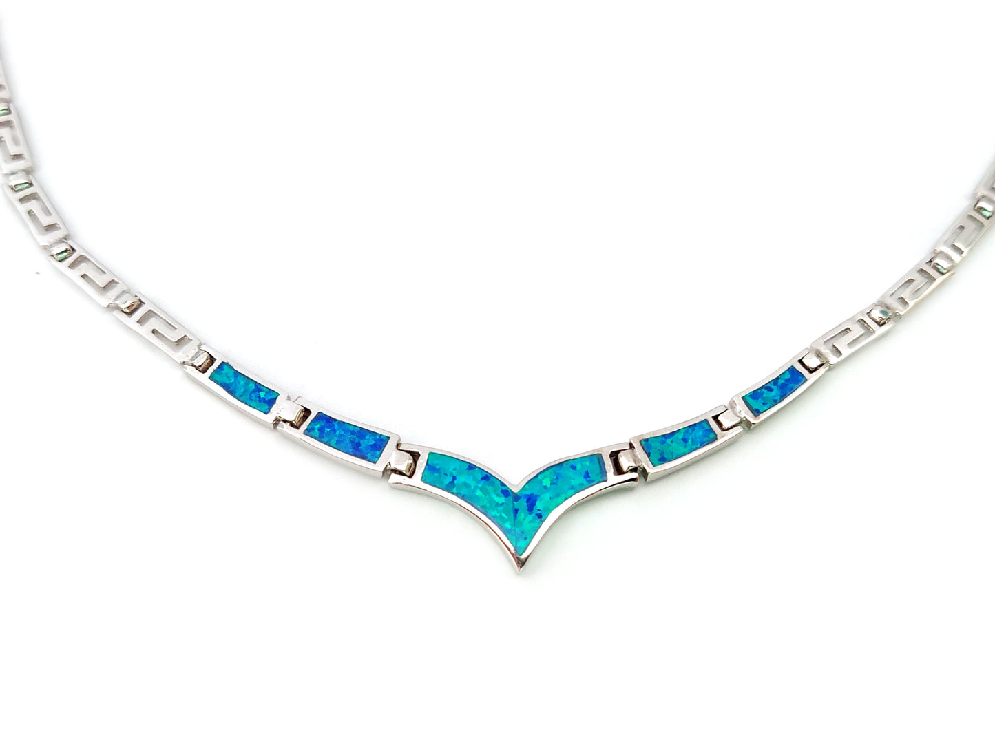 Greek key silver necklace with blue opal stones in v shape on white background.