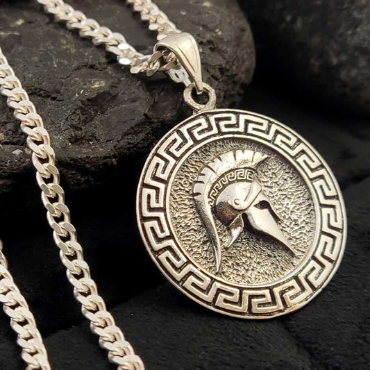 Close-up of Ancient Greek helmet pendant in sterling silver 925, showcasing intricate design and Greek Key border.

