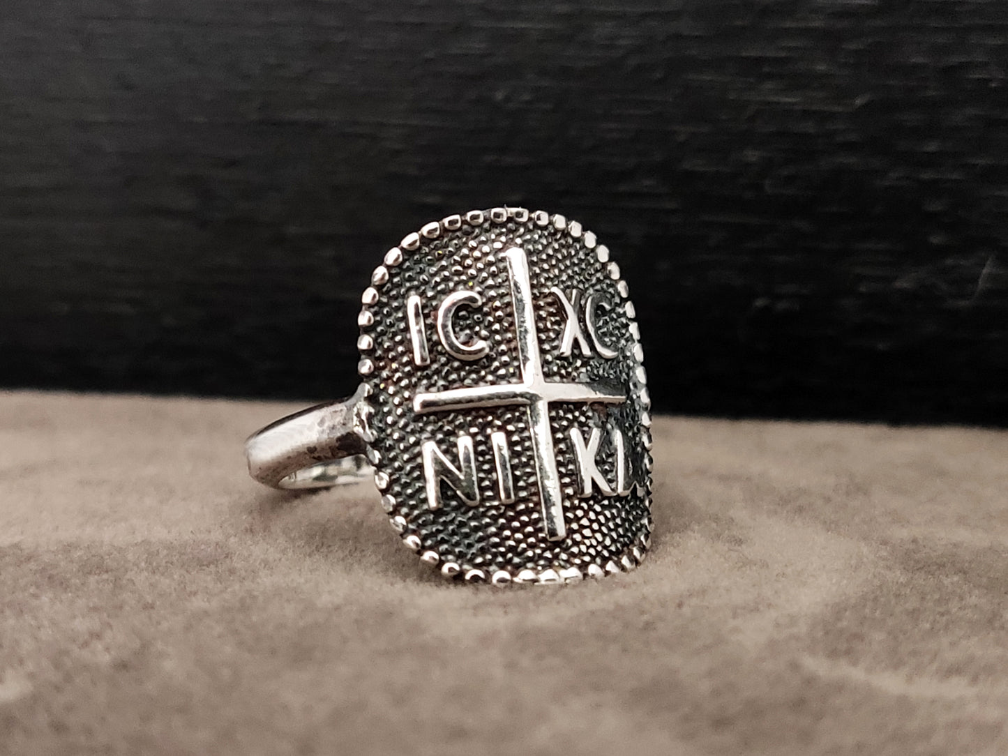 Silver ring with the konstantinato byzantine design. it has a cross in the middle and the letters  ICXC NIKA .
