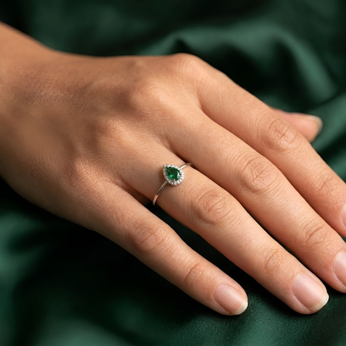 Modern silver jewelry ring with pear-shaped green crystal centerpiece