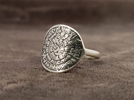 Phaistos Disc Greek silver 925 ring on gray velvet background.