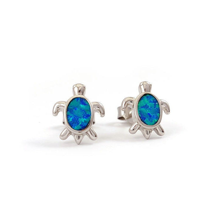 Turtle-shaped earrings with blue opal stones on a white background
