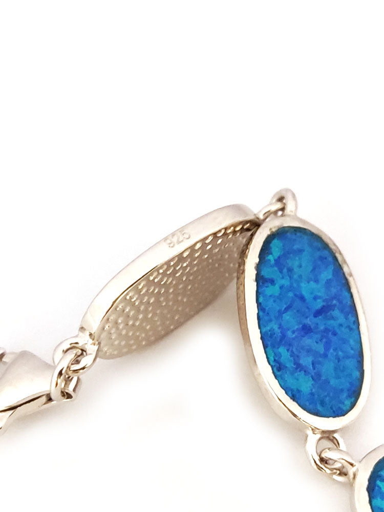 "Blue Opal Greek Silver Bracelet displayed on a jewelry stand, highlighting its timeless design."





