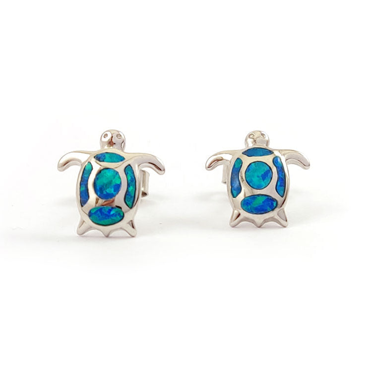 Turtle-shaped earrings with blue opal inlay on a white background