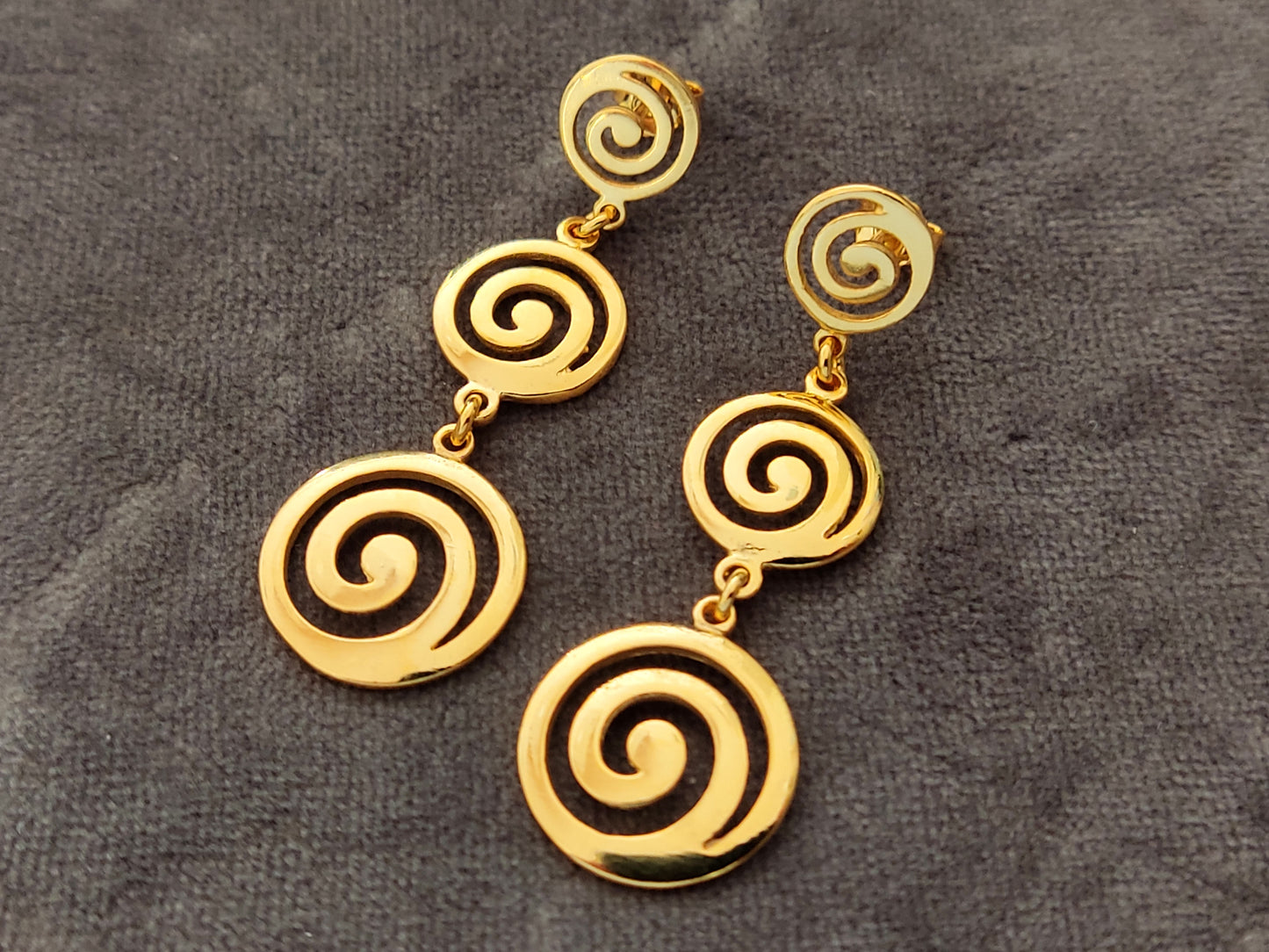 Greek spiral dangle long earrings made of Sterling Silver 925 with gold plated finish on gray velvet.