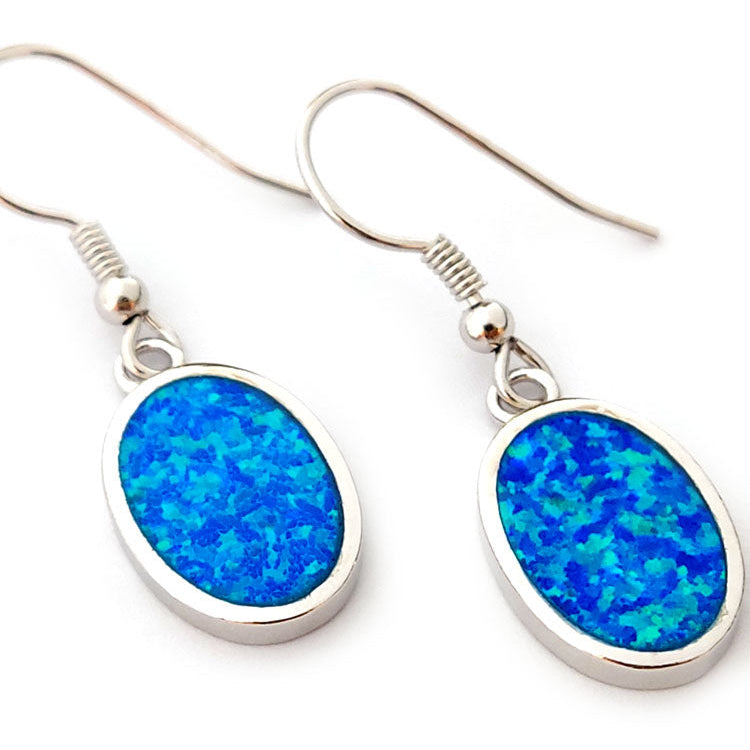 Blue opal oval shaped stones and sterling silver 925 dangle earrings on white background.