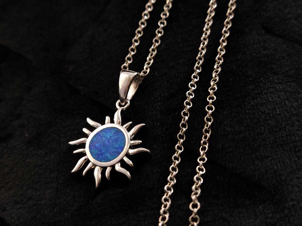 Detail of blue opal stone in the sun design pendant, sterling silver.
