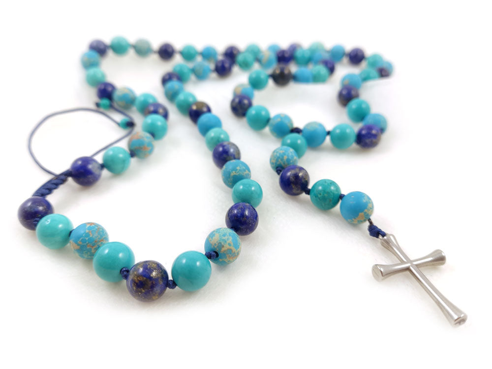 Close-up of handmade necklace featuring natural Lapis Lazuli, Turquoise, and Agate stones with a stainless steel cross.