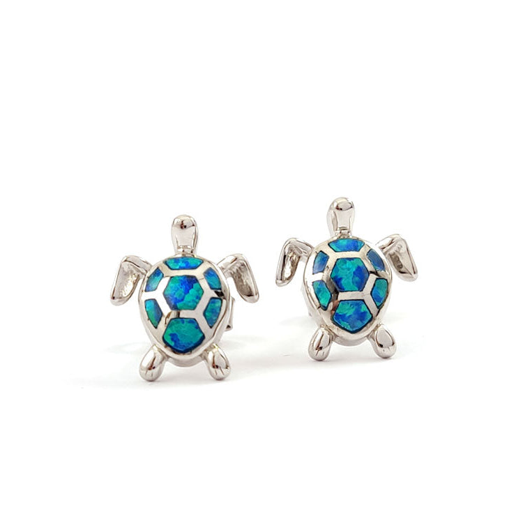 Turtle-shaped earrings with blue opal inlay on a white background
