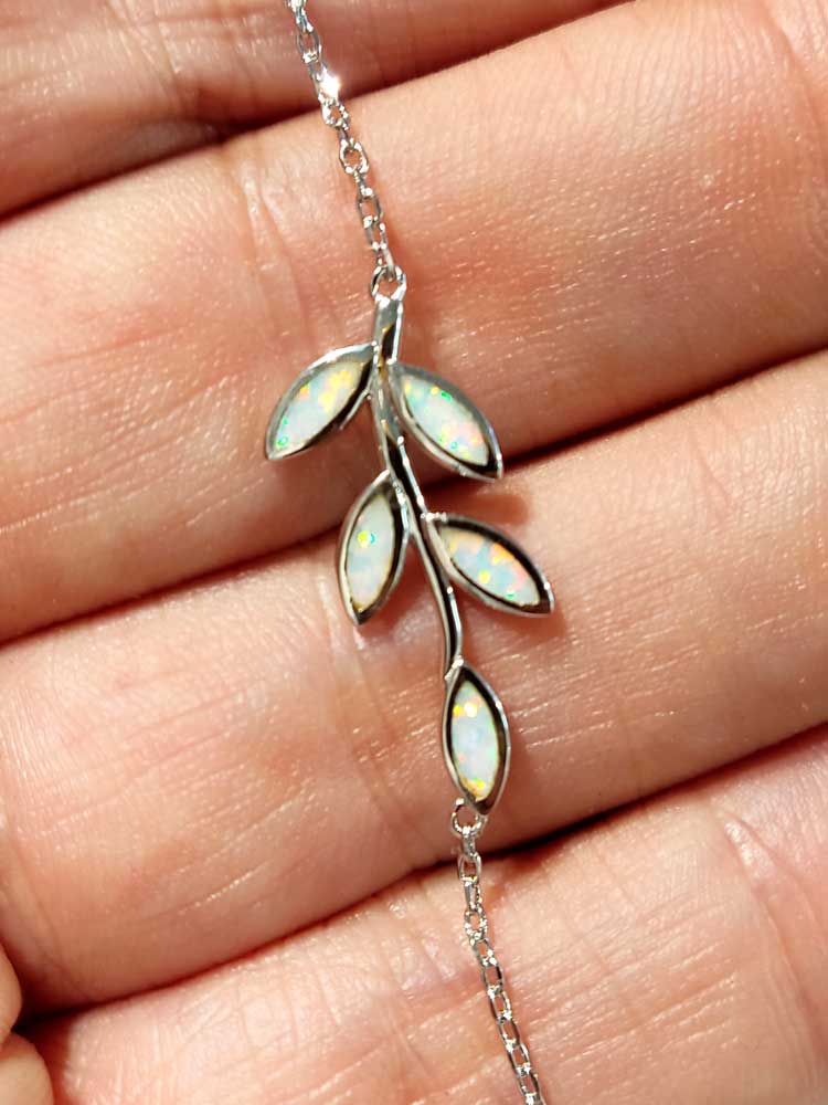 Close-up photo of the white opal stones in leaves shape . The photo shows the various glows of the white opal stones.