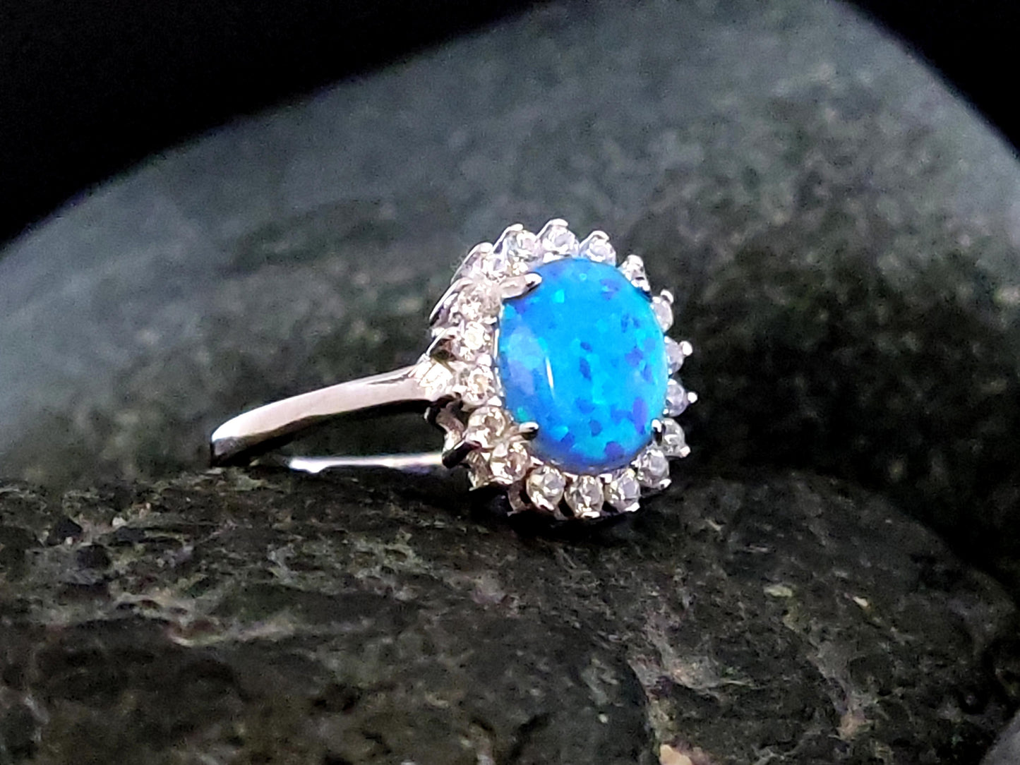 blue opal rosetta silver ring made in Greece on a black rock.