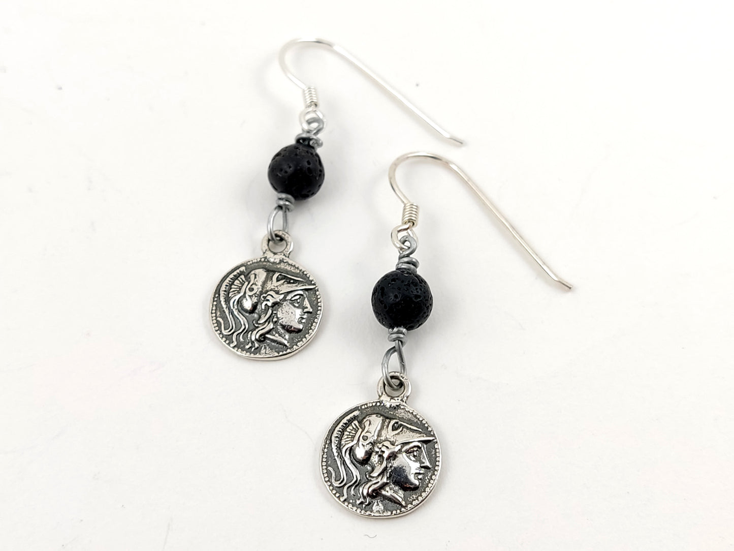 Silver and lava stones earrings depicting Athena on white background.