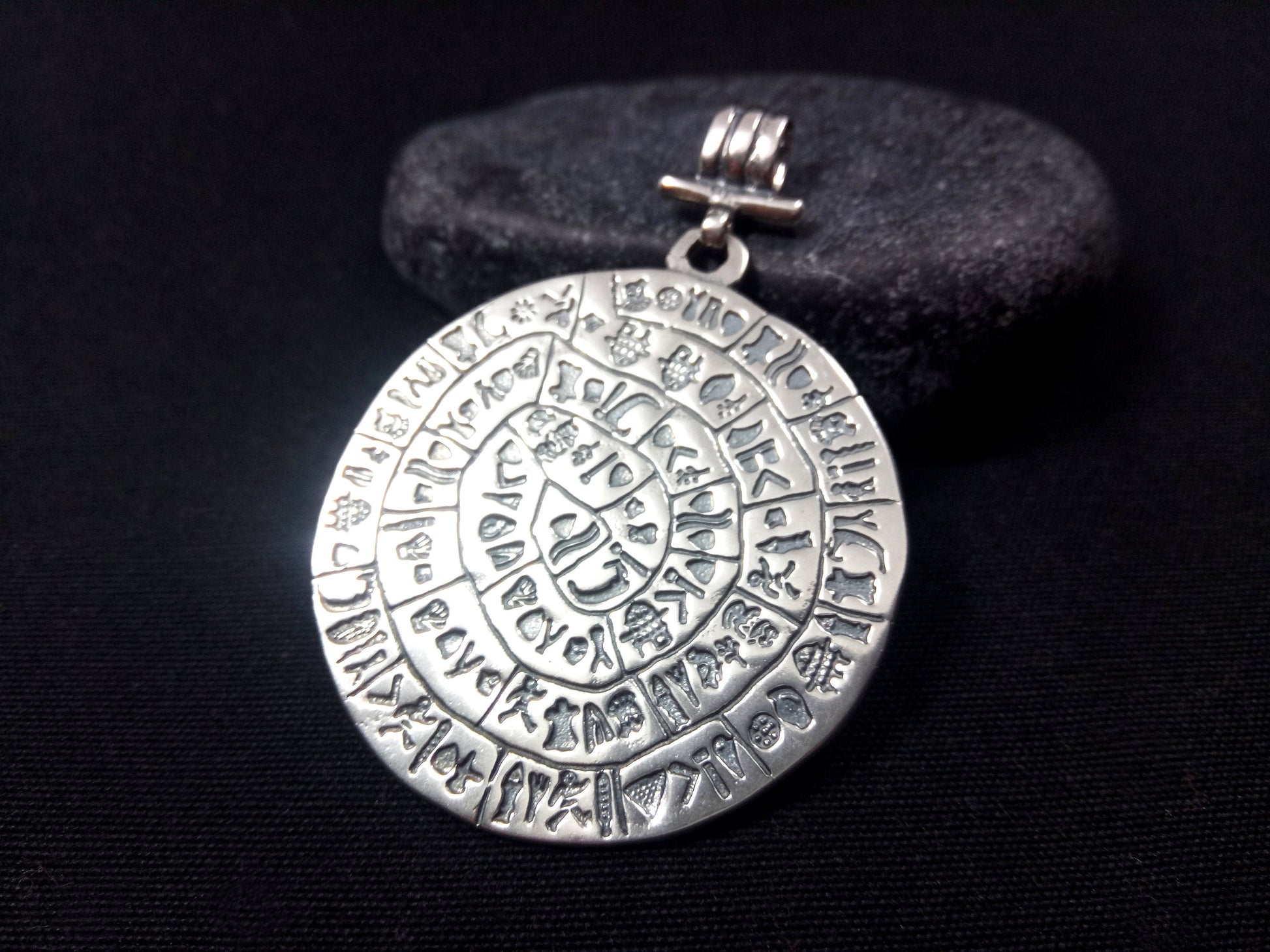 Close-up of Sterling Silver 925 Phaistos Disc Pendant, 43 mm (1.67 inches) in size, showcasing intricate ancient Greek craftsmanship, a symbol of history and culture.