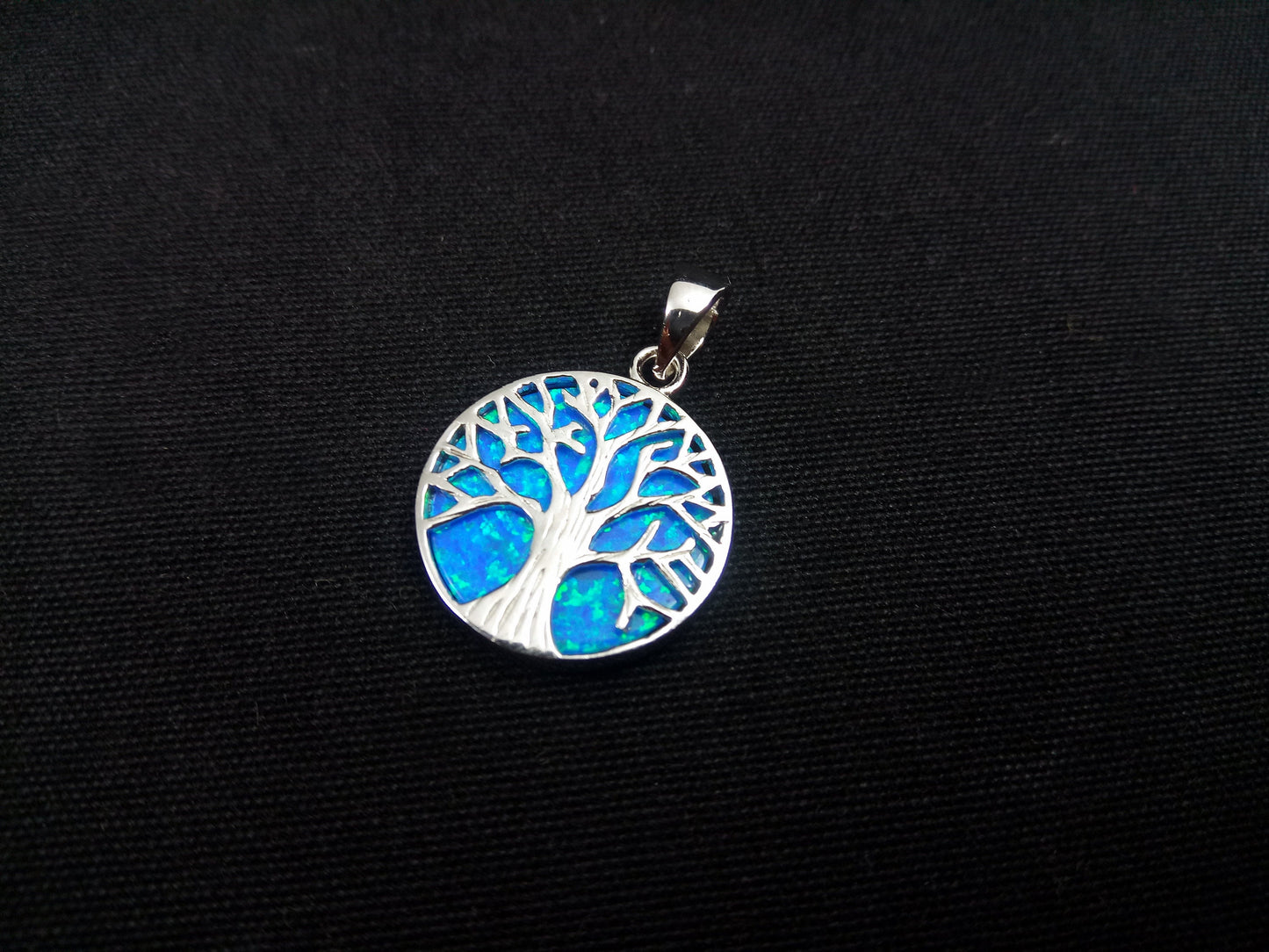Sterling silver 925 pendant featuring a beautiful blue opal tree of life design. The pendant measures 18mm in diameter.