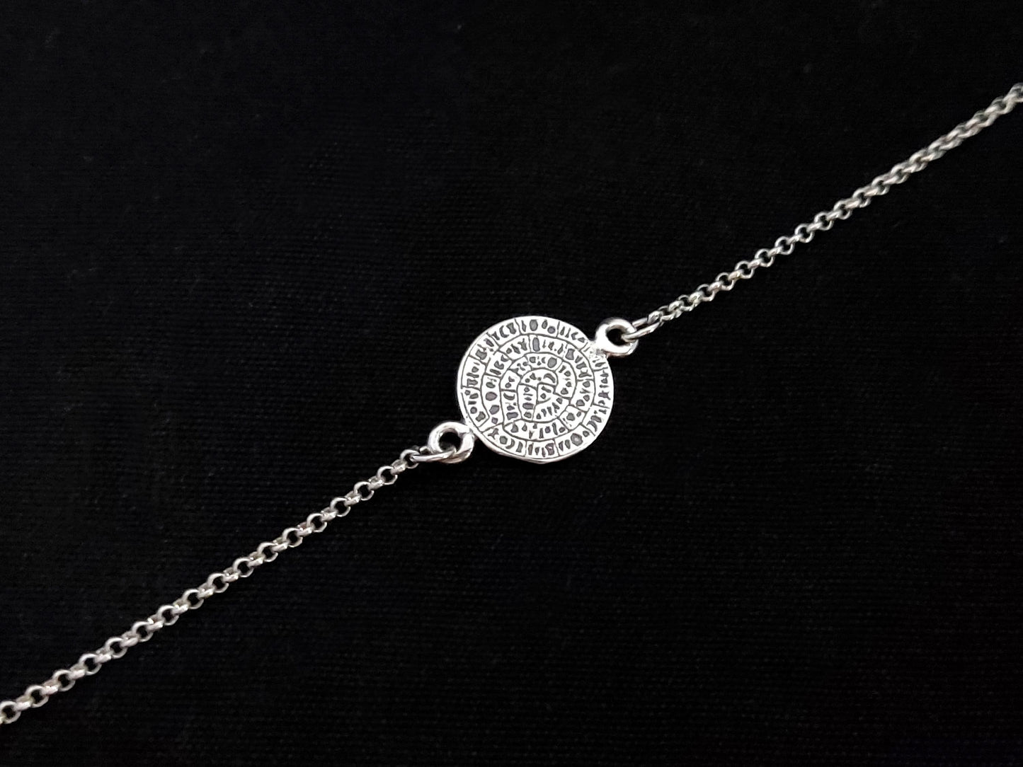 Sterling Silver 925 adjustable bracelet with ancient Greek Minoan Phaistos Disc as centerpiece. Bracelet adjustable from 17-20 cm, 6.63-7.80 inches and 2 mm wide. Disc measures 10 mm in diameter. Hallmarked 925, made in Greece. Free Shipping Included.